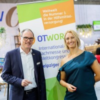 Two people stand on a gallery in the Glass Hall of the Leipzig Trade Fair above a banner with the OTWorld logo and the text “AUF WIEDERSEHEN • SEE YOU AGAIN 15 – 18 MAY 2018”. Two people stand on a gallery in the Glass Hall of the Leipzig Trade Fair above a banner with the OTWorld logo and the text “AUF WIEDERSEHEN • SEE YOU AGAIN 15 – 18 MAY 2018”.