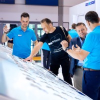 Zwei Messebesucher führen ein Beratungsgespräch an einem Messestand. Zwei Messebesucher führen ein Beratungsgespräch an einem Messestand.