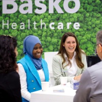 Gesprächssituation am Messestand: Sechs Personen lachen sich an. Gesprächssituation am Messestand: Sechs Personen lachen sich an.