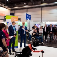 Gesprächsituation: Ein Mann mit Mikrofon redet vor zahlreichen Messebesuchern. Gesprächsituation: Ein Mann mit Mikrofon redet vor zahlreichen Messebesuchern.