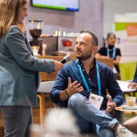 Ein Mann, sitzend auf einem Stuhl, wird von einer Frau interviewt. Ein Mann, sitzend auf einem Stuhl, wird von einer Frau interviewt.