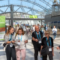 Besuchergruppe mit Lanyards geht durch die Glashalle der Leipziger Messe, neben einem Hinweisschild mit dem Motto ‚Du machst den Unterschied!‘. Besuchergruppe mit Lanyards geht durch die Glashalle der Leipziger Messe, neben einem Hinweisschild mit dem Motto ‚Du machst den Unterschied!‘.