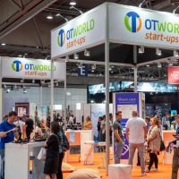 Gut besuchter Messestand, darüber in goßen Lettern: "OTWorld start-ups". Gut besuchter Messestand, darüber in goßen Lettern: "OTWorld start-ups".