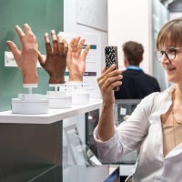 Eine Besucherin fotografiert detailgetreue prothetische Handmodelle auf der OTWorld. Eine Besucherin fotografiert detailgetreue prothetische Handmodelle auf der OTWorld.